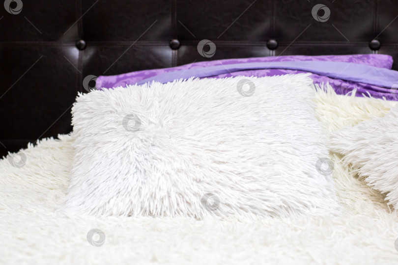 Скачать Мягкие текстуры и теплое освещение, современная спальня с плюшевой подушкой и элегантными акцентами фотосток Ozero