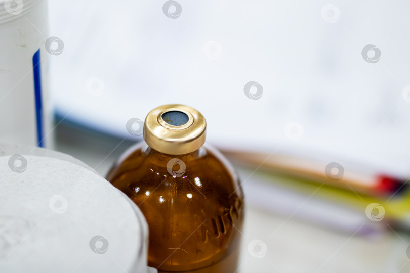 Скачать Фокус на флаконе с вакциной, детальный снимок, показывающий флакон с вакциной с металлической пломбой на лабораторном столе фотосток Ozero