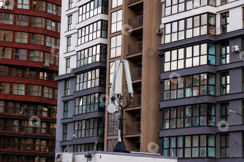 Скачать Ночной городской квартал с рабочими, ремонтирующими спутниковые антенны на крышах фотосток Ozero