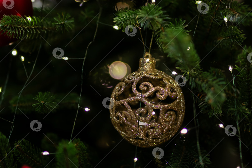 Скачать Изысканное золотое украшение, украшенное мерцающими вставками на вечнозеленых ветвях фотосток Ozero