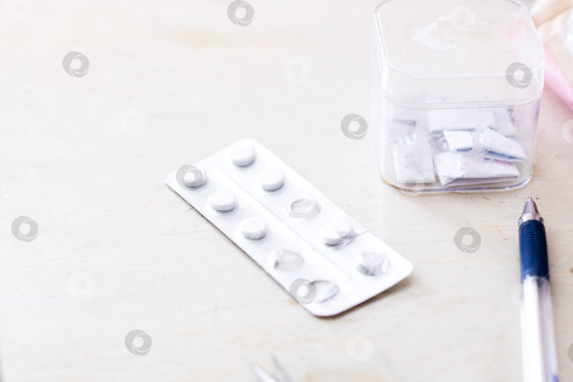 Скачать Подробный вид лекарств и письменных принадлежностей на поверхности с нейтральной деревянной текстурой фотосток Ozero