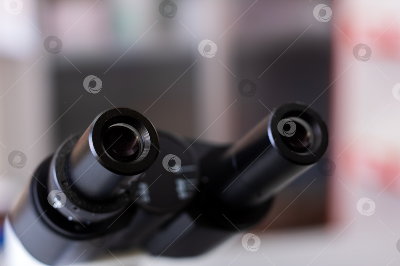Скачать Четкое изображение, фокусирующееся на окулярах микроскопа, с мягко затемненной лабораторной обстановкой на заднем плане фотосток Ozero