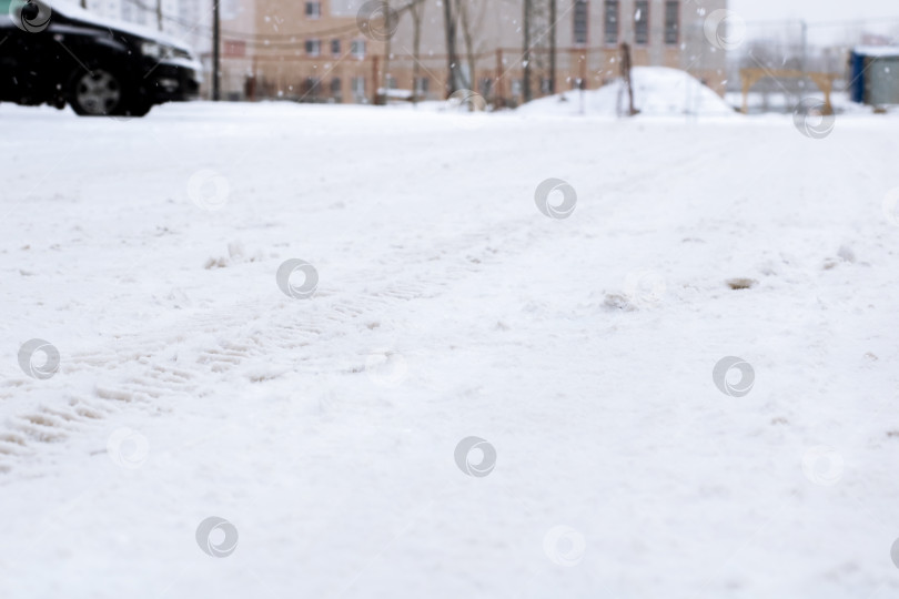 Скачать Городская улица, покрытая снегом, Тихая городская дорога, покрытая снегом и разбросанными следами фотосток Ozero