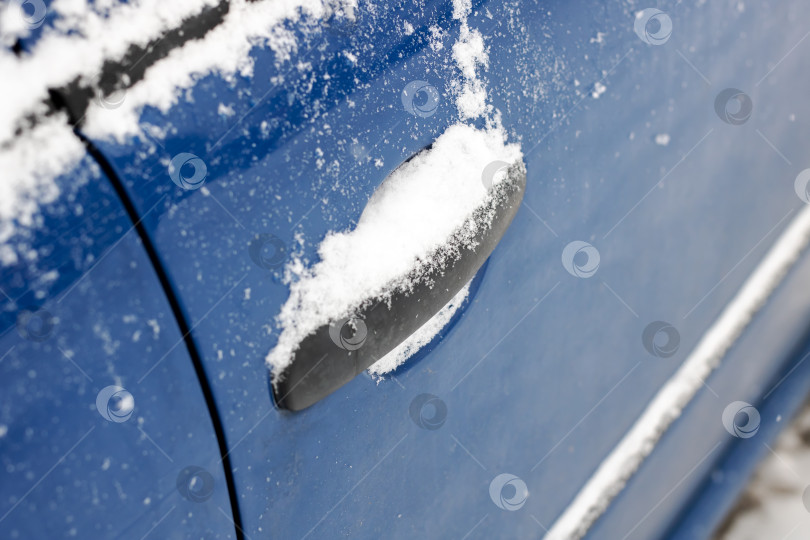 Скачать Изображение дверной ручки автомобиля крупным планом, покрытой снегом, с обледенелыми краями и текстурированной поверхностью фотосток Ozero