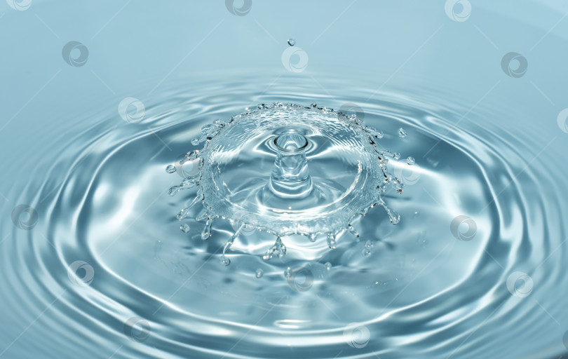 Скачать Капли чистой и пресной воды падают с высоты чистой, прозрачно-голубой воды, образуя брызги в виде оригинальных фигур фотосток Ozero