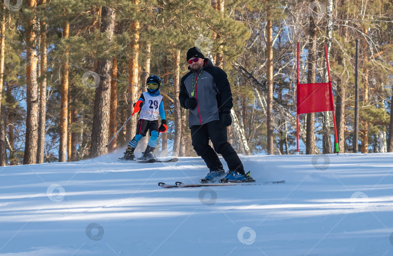 Скачать Россия, Красноярск 25 февраля 2025г. Спортивный тренер и инструктор по лыжному спорту работает со своими учениками на заснеженном горнолыжном склоне. фотосток Ozero