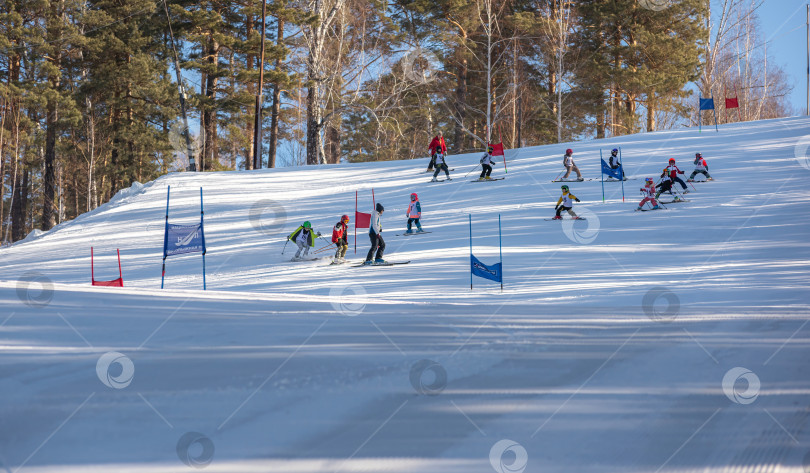 Скачать Россия, Красноярск 25 февраля 2025г. Спортивный тренер и инструктор по лыжному спорту работает со своими учениками на заснеженном горнолыжном склоне. фотосток Ozero