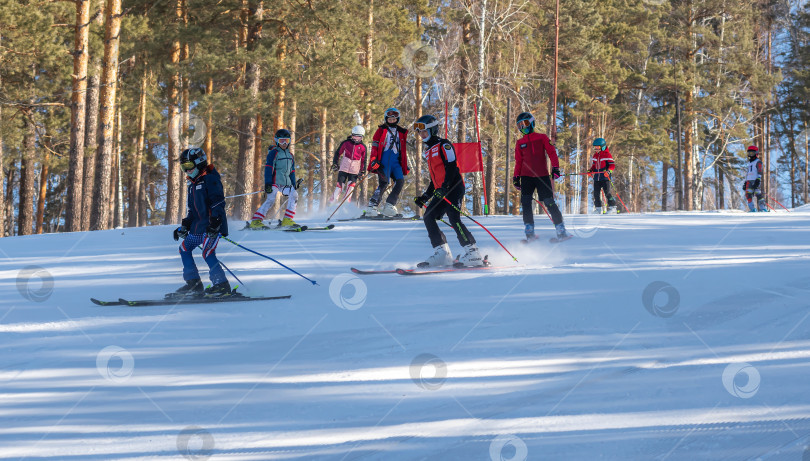 Скачать Россия, Красноярск 25 февраля 2025г. Спортивный тренер и инструктор по лыжному спорту работает со своими учениками на заснеженном горнолыжном склоне. фотосток Ozero