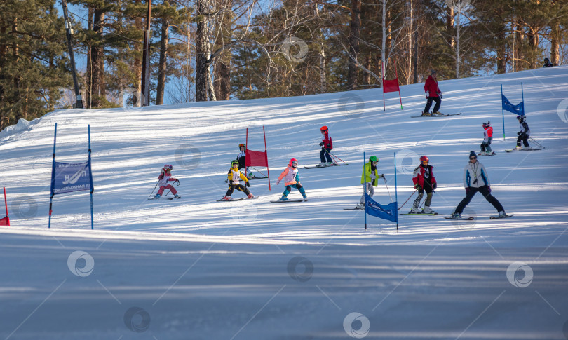 Скачать Россия, Красноярск 25 февраля 2025г. Спортивный тренер и инструктор по лыжному спорту работает со своими учениками на заснеженном горнолыжном склоне. фотосток Ozero