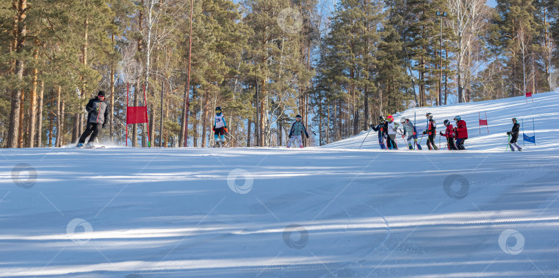 Скачать Россия, Красноярск 25 февраля 2025г. Спортивный тренер и инструктор по лыжному спорту работает со своими учениками на заснеженном горнолыжном склоне. фотосток Ozero