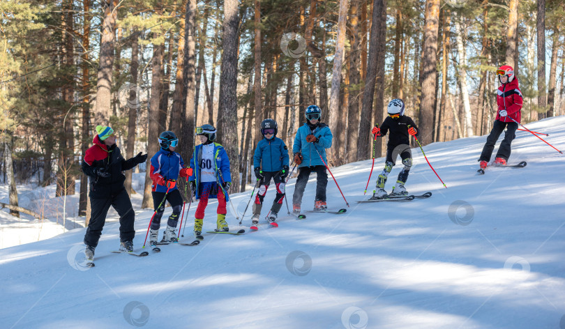 Скачать Россия, Красноярск 25 февраля 2025г. Спортивный тренер и инструктор по лыжному спорту работает со своими учениками на заснеженном горнолыжном склоне. фотосток Ozero
