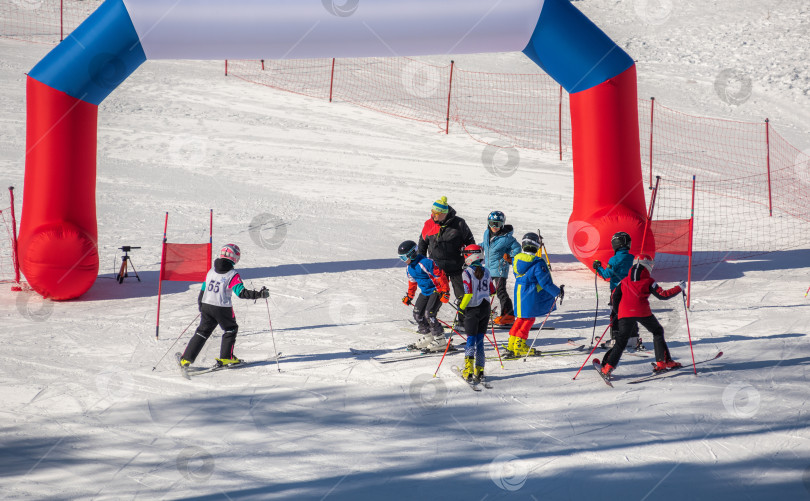 Скачать Россия, Красноярск 25 февраля 2025г. Спортивный тренер и инструктор по лыжному спорту работает со своими учениками на заснеженном горнолыжном склоне. фотосток Ozero