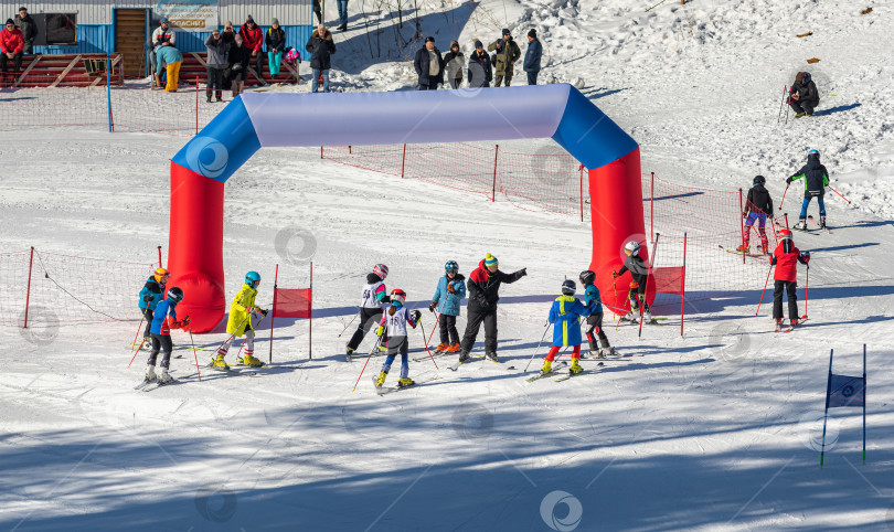 Скачать Россия, Красноярск 25 февраля 2025г. Спортивный тренер и инструктор по лыжному спорту работает со своими учениками на заснеженном горнолыжном склоне. фотосток Ozero