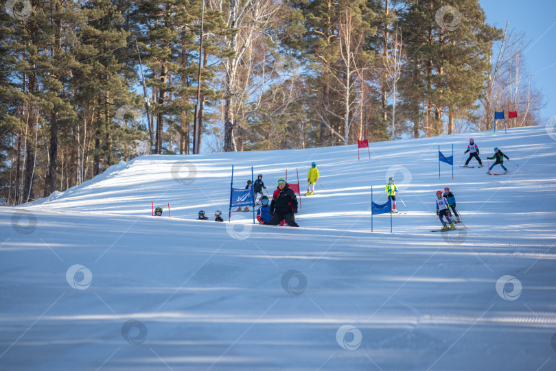 Скачать Россия, Красноярск 25 февраля 2025г. Спортивный тренер и инструктор по лыжному спорту работает со своими учениками на заснеженном горнолыжном склоне. фотосток Ozero