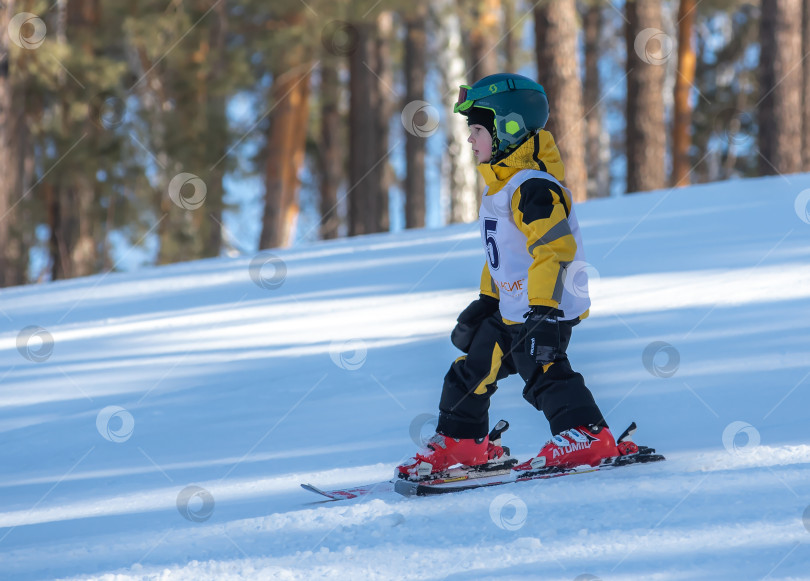 Скачать Россия, Красноярск 25 февраля 2025г. Мальчик лыжник, спускается на лыжах по снежному склону. фотосток Ozero