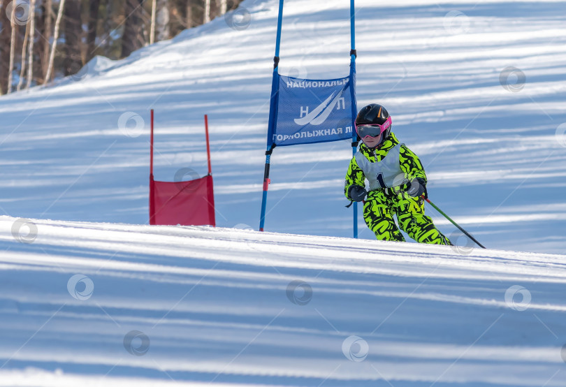 Скачать Россия, Красноярск 25 февраля 2025г. Мальчик лыжник, спускается на лыжах по снежному склону. фотосток Ozero