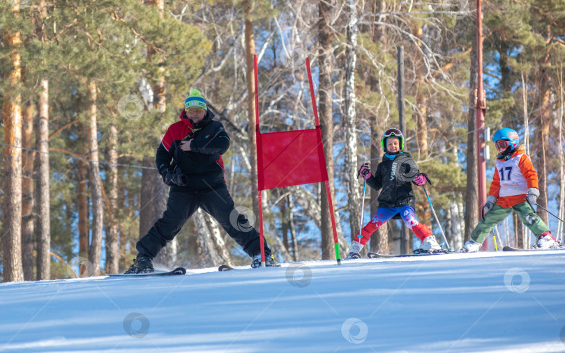 Скачать Россия, Красноярск 25 февраля 2025г. Спортивный тренер и инструктор по лыжному спорту работает со своими учениками на заснеженном горнолыжном склоне. фотосток Ozero