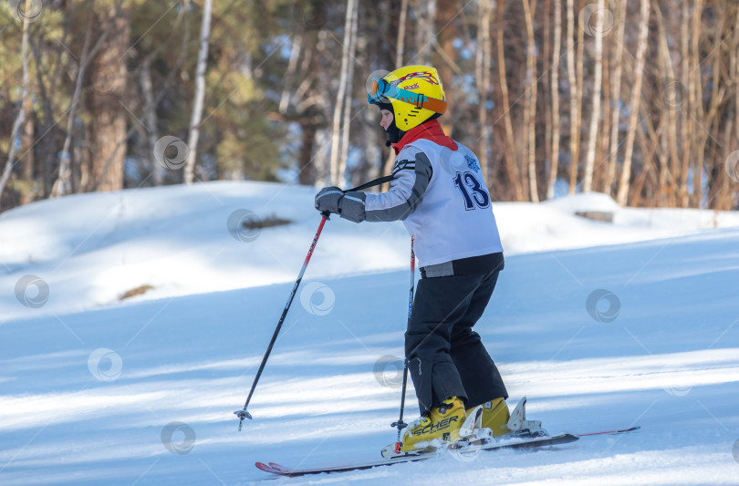 Скачать Россия, Красноярск 25 февраля 2025г. Мальчик лыжник, спускается на лыжах по снежному склону. фотосток Ozero