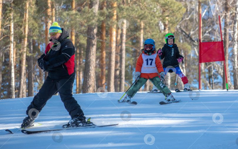 Скачать Россия, Красноярск 25 февраля 2025г. Спортивный тренер и инструктор по лыжному спорту работает со своими учениками на заснеженном горнолыжном склоне. фотосток Ozero