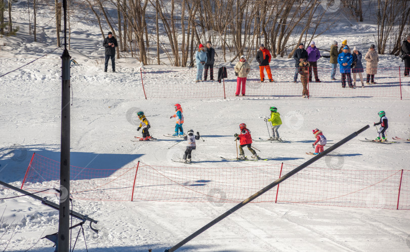 Скачать Россия, Красноярск 25 февраля 2025г. Спортивный тренер и инструктор по лыжному спорту работает со своими учениками на заснеженном горнолыжном склоне. фотосток Ozero