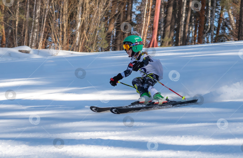 Скачать Россия, Красноярск 25 февраля 2025г. Девочка лыжница, спускается на лыжах по снежному склону. фотосток Ozero