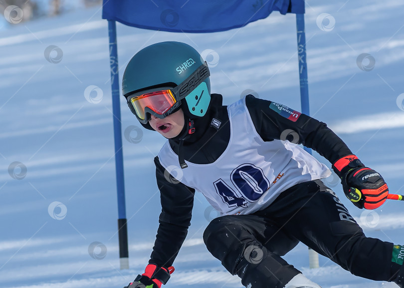 Скачать Россия, Красноярск 25 февраля 2025г. Мальчик лыжник, спускается на лыжах по снежному склону. фотосток Ozero
