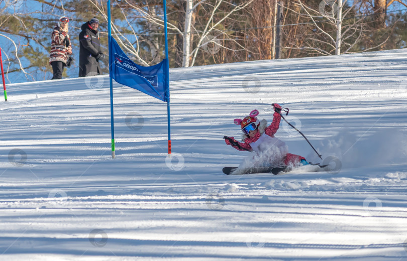 Скачать Россия, Красноярск 25 февраля 2025г. Маленькая девочка лыжница, спускается на лыжах по снежному склону. фотосток Ozero