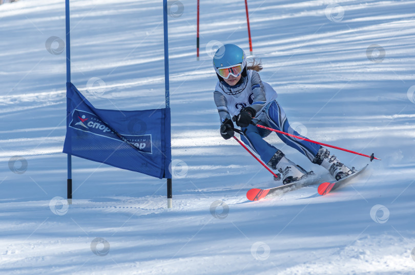 Скачать Россия, Красноярск 25 февраля 2025г. Девочка лыжница, спускается на лыжах по снежному склону. фотосток Ozero