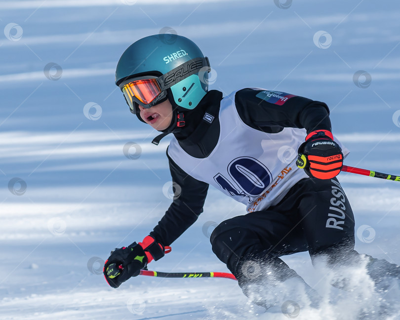 Скачать Россия, Красноярск 25 февраля 2025г. Мальчик лыжник, спускается на лыжах по снежному склону. фотосток Ozero