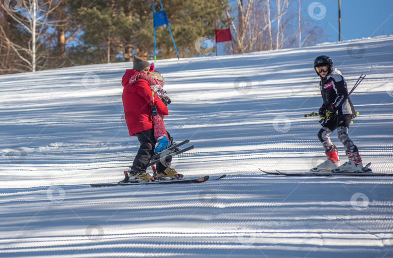 Скачать Россия, Красноярск 25 февраля 2025г. Спортивный тренер и инструктор по лыжному спорту работает со своими учениками на заснеженном горнолыжном склоне. фотосток Ozero