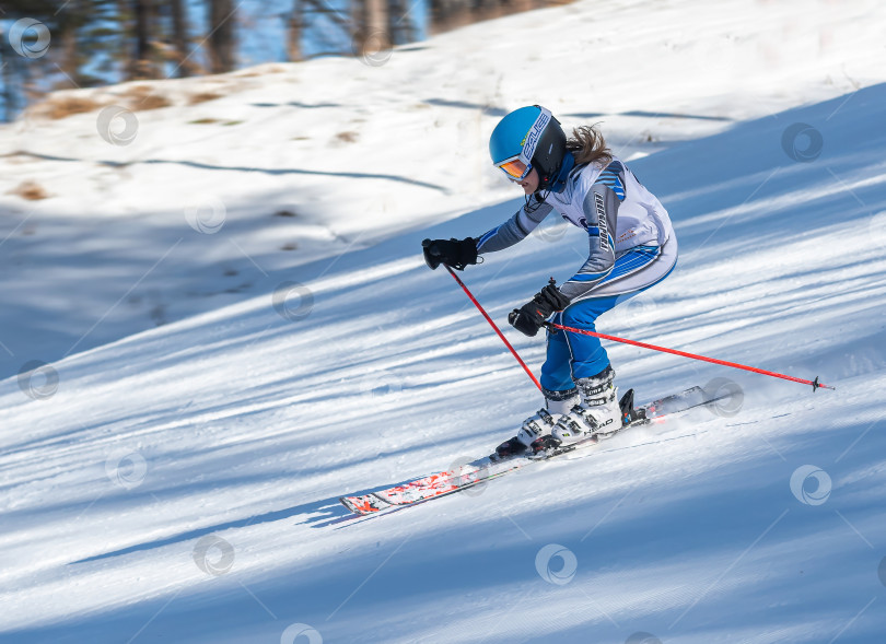 Скачать Россия, Красноярск 25 февраля 2025г. Девочка лыжница, спускается на лыжах по снежному склону. фотосток Ozero