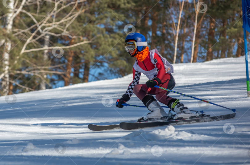 Скачать Россия, Красноярск 25 февраля 2025г. Мальчик лыжник, спускается на лыжах по снежному склону. фотосток Ozero