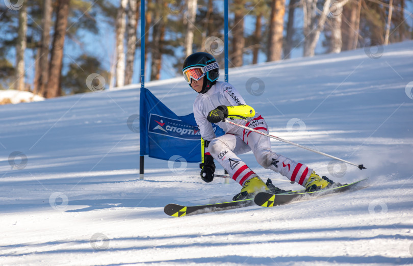 Скачать Россия, Красноярск 25 февраля 2025г. Мальчик лыжник, спускается на лыжах по снежному склону. фотосток Ozero