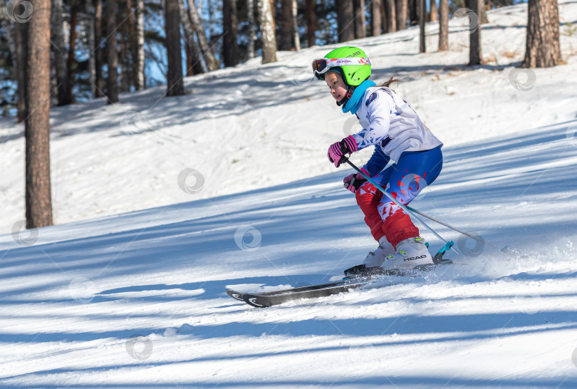 Скачать Россия, Красноярск 25 февраля 2025г. Девочка лыжница, спускается на лыжах по снежному склону. фотосток Ozero