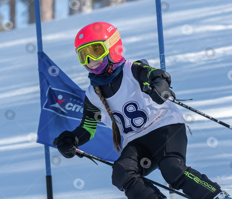 Скачать Россия, Красноярск 25 февраля 2025г. Девочка лыжница, спускается на лыжах по снежному склону. фотосток Ozero