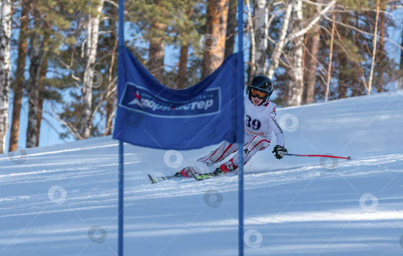 Скачать Россия, Красноярск 25 февраля 2025г. Мальчик лыжник, спускается на лыжах по снежному склону. фотосток Ozero