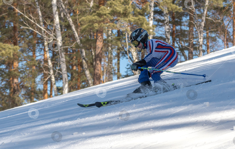 Скачать Россия, Красноярск 25 февраля 2025г. Мальчик лыжник, спускается на лыжах по снежному склону. фотосток Ozero