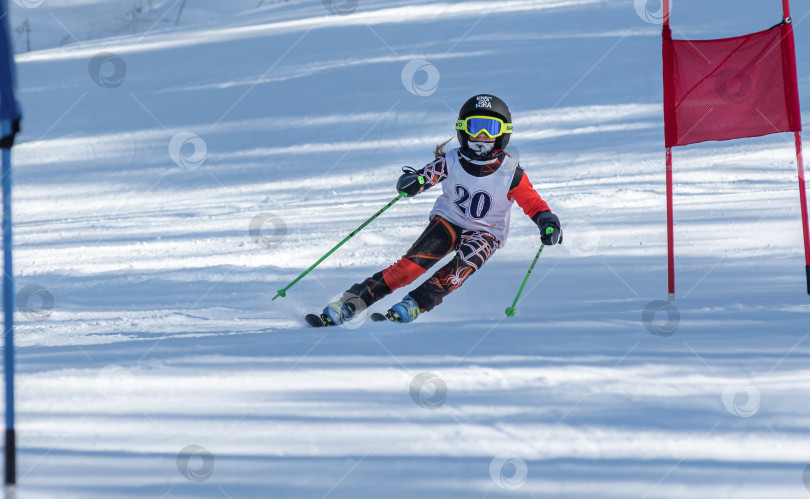 Скачать Россия, Красноярск 25 февраля 2025г. Девочка лыжница, спускается на лыжах по снежному склону. фотосток Ozero