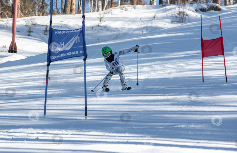 Скачать Россия, Красноярск 25 февраля 2025г. Мальчик лыжник, спускается на лыжах по снежному склону. фотосток Ozero