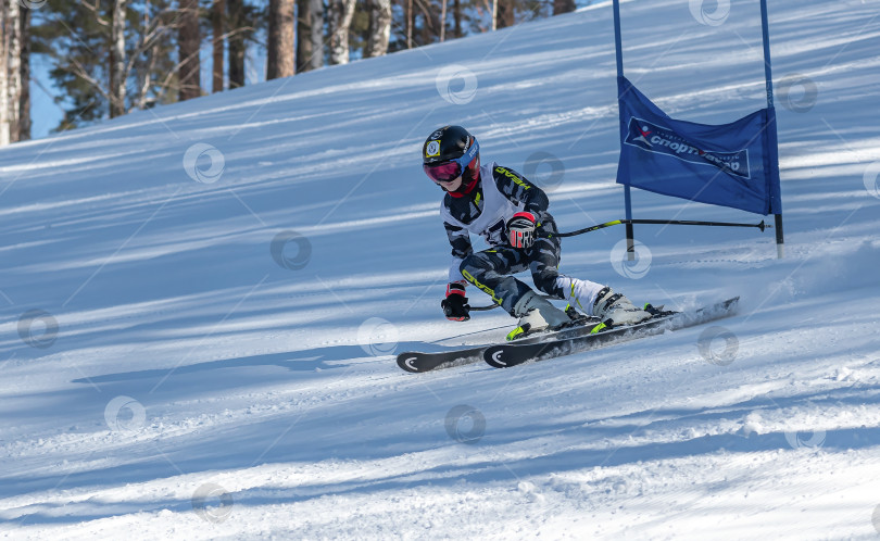Скачать Россия, Красноярск 25 февраля 2025г. Мальчик лыжник, спускается на лыжах по снежному склону. фотосток Ozero