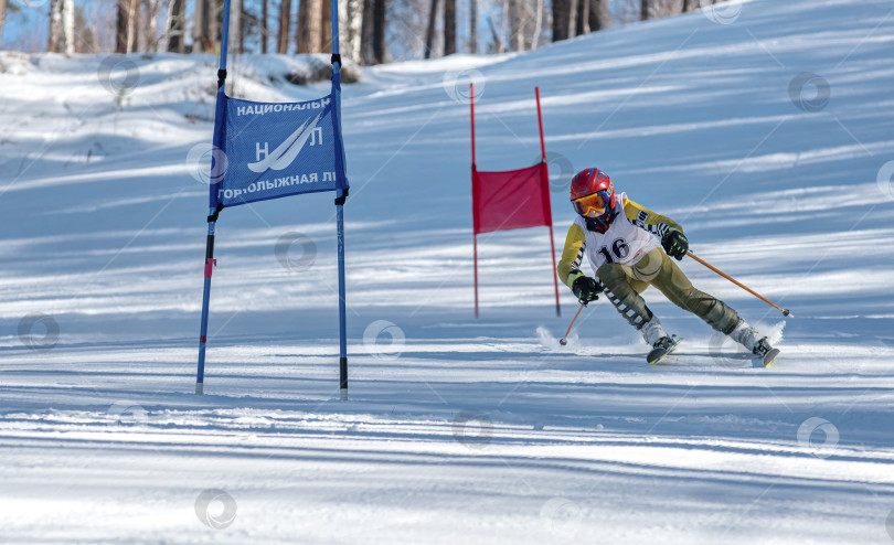 Скачать Россия, Красноярск 25 февраля 2025г. Мальчик лыжник, спускается на лыжах по снежному склону. фотосток Ozero