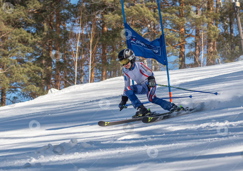 Скачать Россия, Красноярск 25 февраля 2025г. Мальчик лыжник, спускается на лыжах по снежному склону. фотосток Ozero