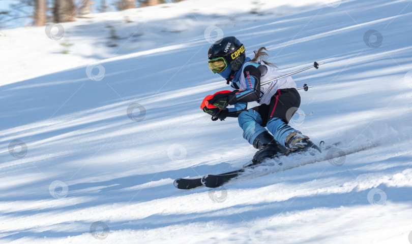 Скачать Россия, Красноярск 25 февраля 2025г. Девочка лыжница, спускается на лыжах по снежному склону. фотосток Ozero