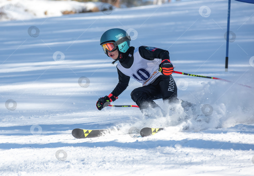 Скачать Россия, Красноярск 25 февраля 2025г. Мальчик лыжник, спускается на лыжах по снежному склону. фотосток Ozero