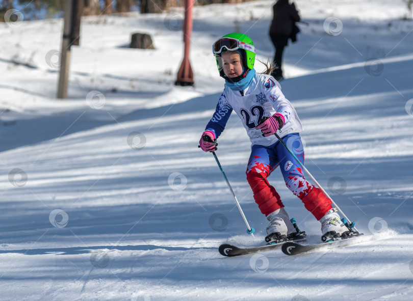 Скачать Россия, Красноярск 25 февраля 2025г. Мальчик лыжник, спускается на лыжах по снежному склону. фотосток Ozero