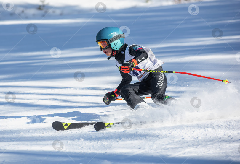 Скачать Россия, Красноярск 25 февраля 2025г. Мальчик лыжник, спускается на лыжах по снежному склону. фотосток Ozero