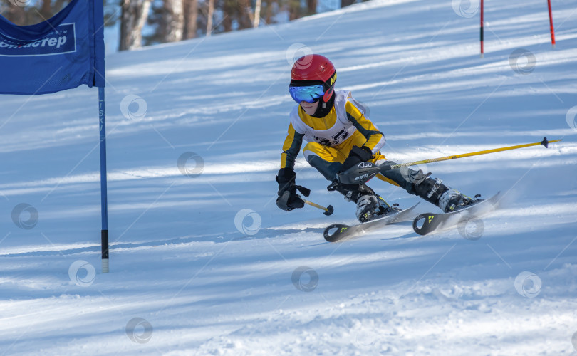 Скачать Россия, Красноярск 25 февраля 2025г. Мальчик лыжник, спускается на лыжах по снежному склону. фотосток Ozero