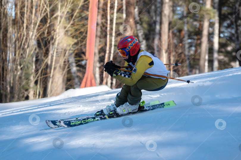 Скачать Россия, Красноярск 25 февраля 2025г. Мальчик лыжник, спускается на лыжах по снежному склону. фотосток Ozero