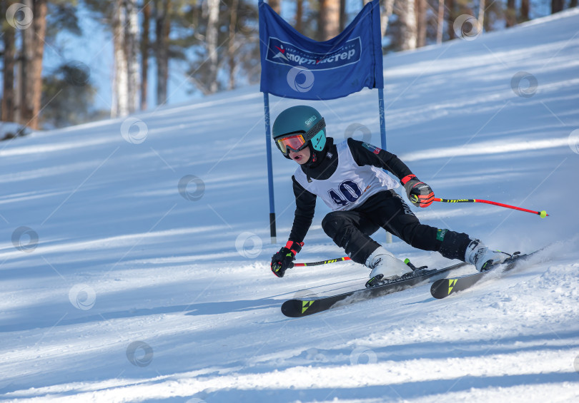 Скачать Россия, Красноярск 25 февраля 2025г. Мальчик лыжник, спускается на лыжах по снежному склону. фотосток Ozero