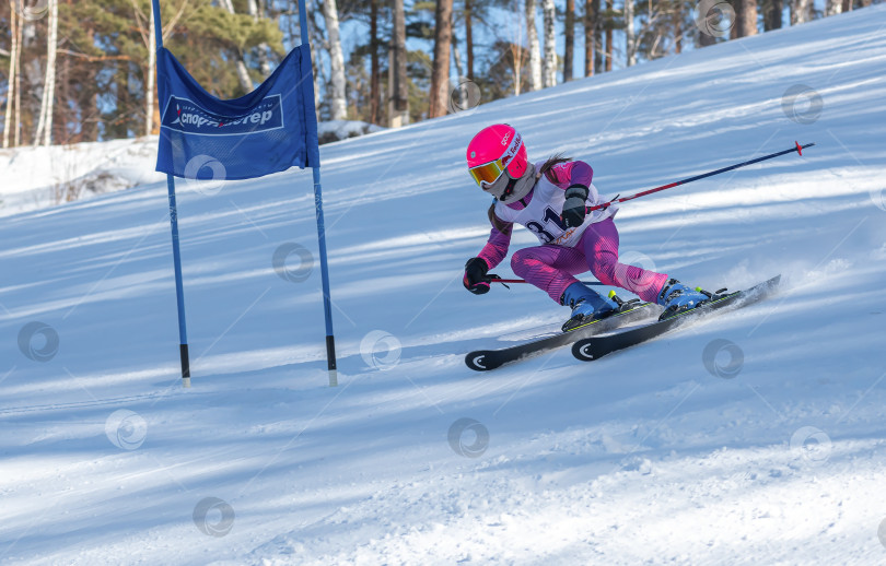 Скачать Россия, Красноярск 25 февраля 2025г. Маленькая девочка лыжница, спускается на лыжах по снежному склону. фотосток Ozero